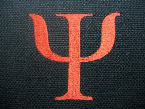 Stitched Psychology symbol in red on a black chair